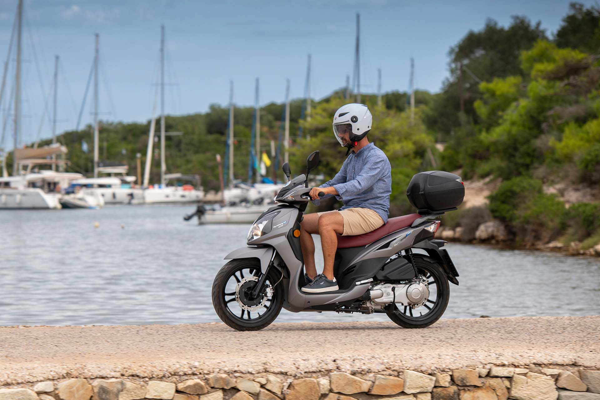 Moto paxos picture of man riding a scooter by the sea